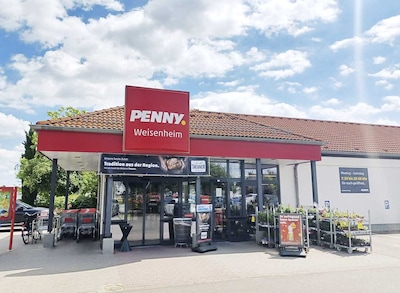 Sie sehen den Eingang vom Penny Markt in Weisenheim Am Sand, Almenweg 4