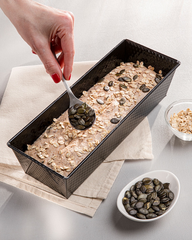 Dieses Bild zeigt, wie die Kerne auf dem Brot verteilt werden.