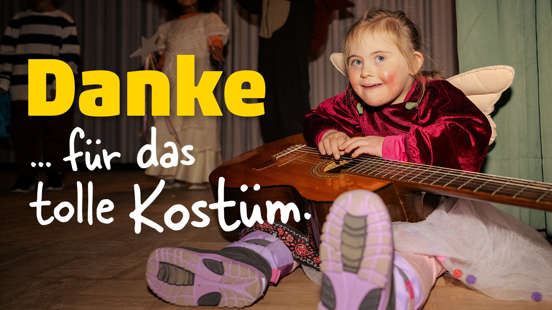 Ein kleines Mädchen im Kostüm mit Gitarre