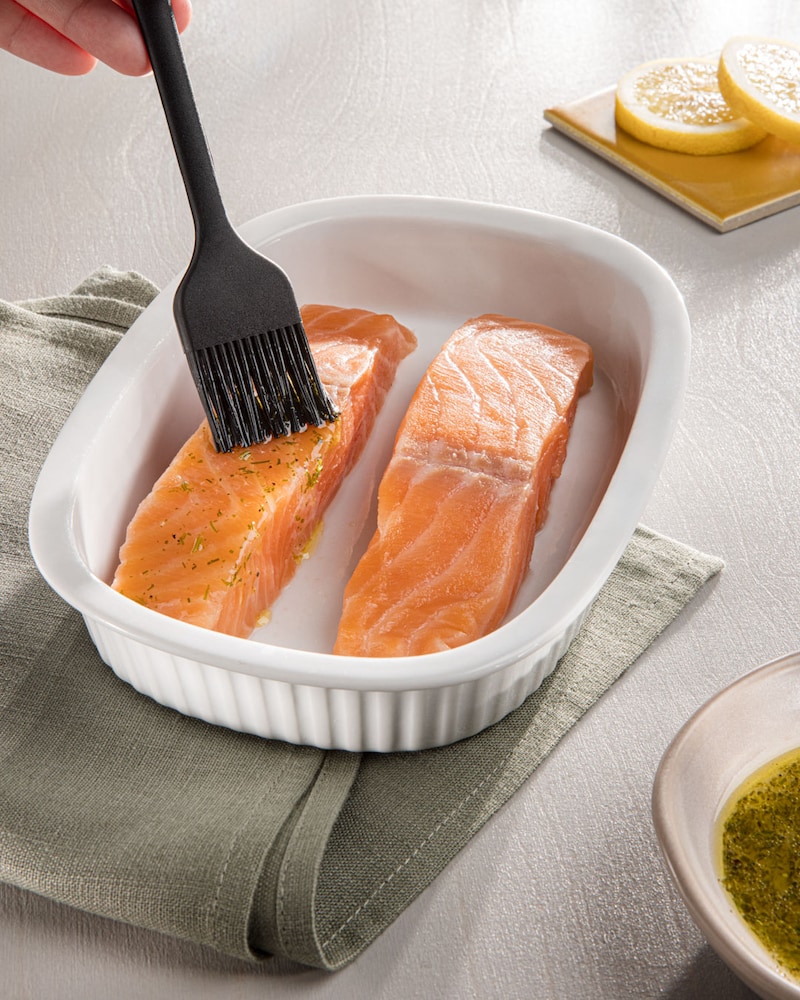 Dieses Bild zeigt wie der Lachs eingepinselt wird.