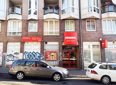 Sie sehen den Eingang vom Penny Markt in Berlin/Neukoelln Emser Str. 1-2