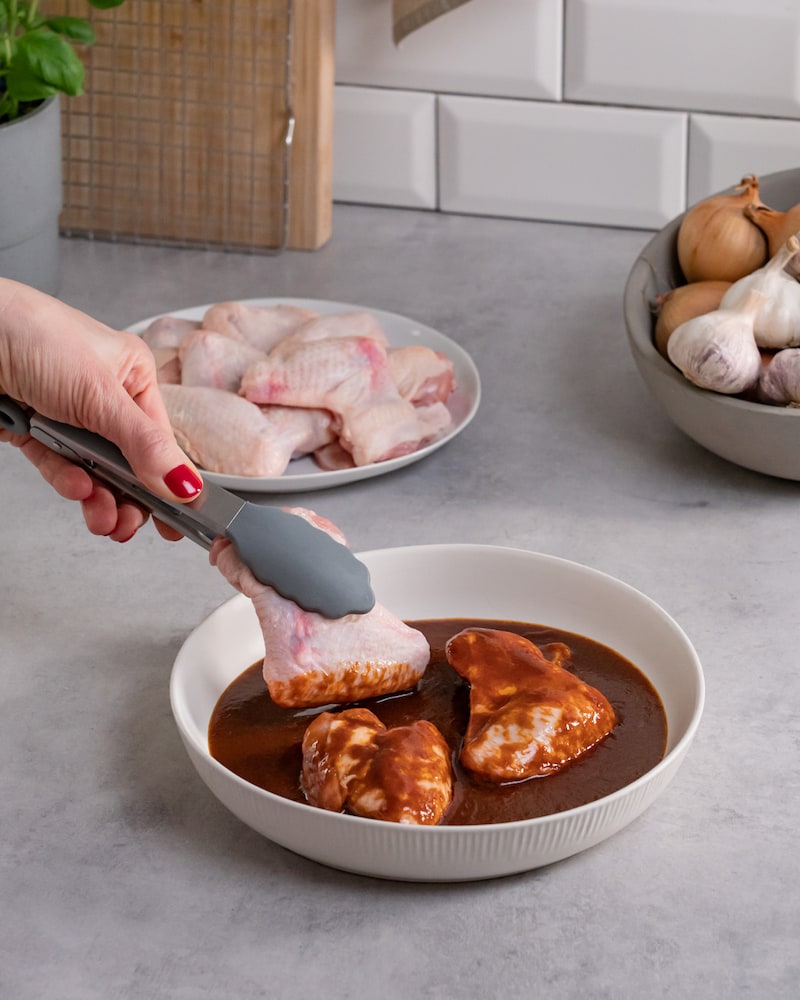 Dieses Bild zeigt, wie die Hähnchenflügel mariniert werden.