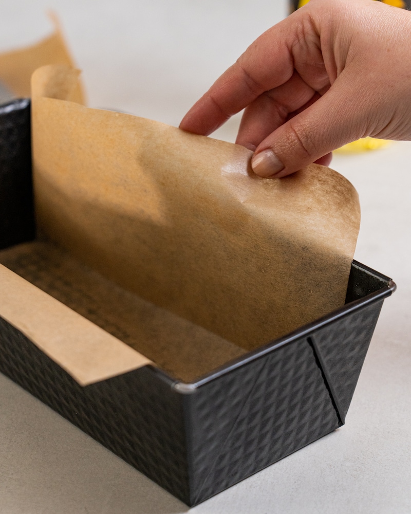 Auf diesem Bild siehst du wie die Form mit Backpapier ausgefüllt wird.