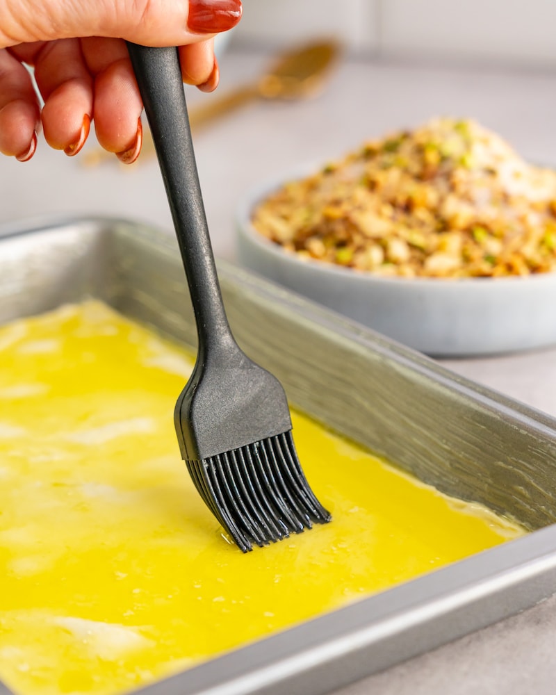 Dieses Bild zeigt wie die Butter auf dem Blätterteig verteilt wird.