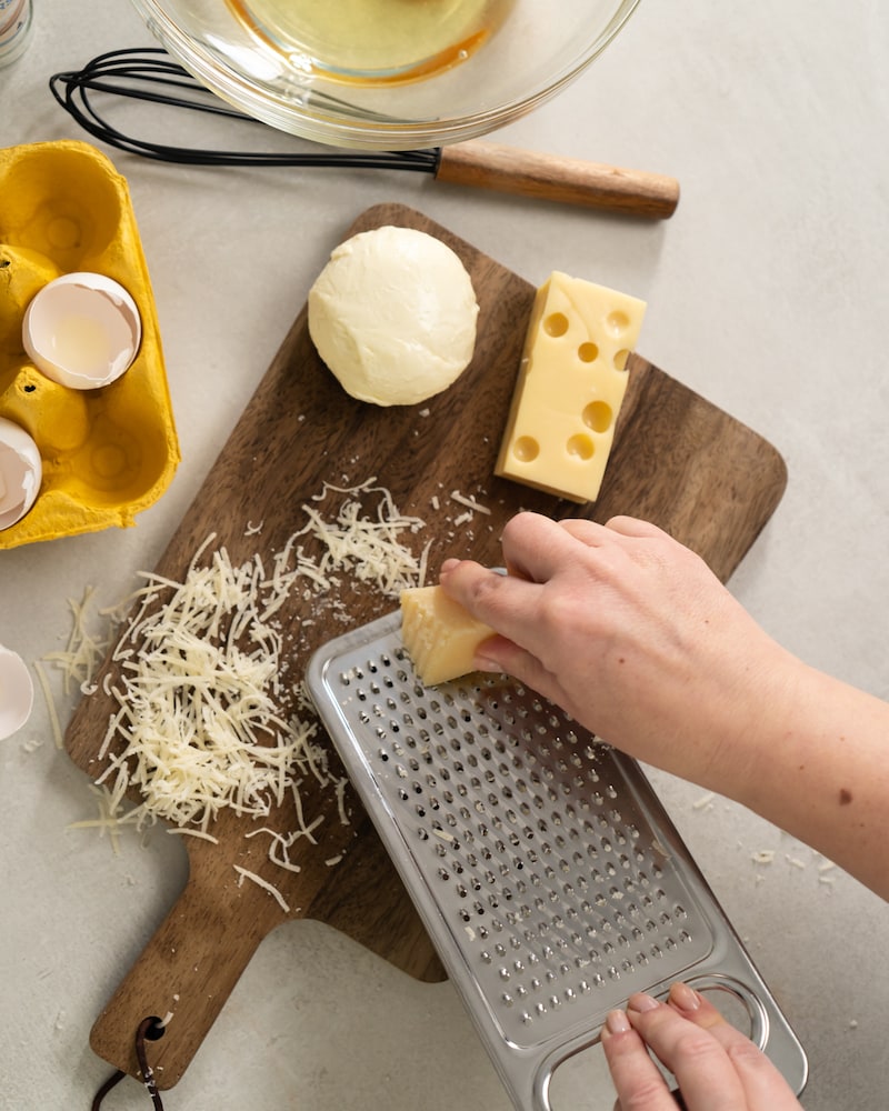 Auf diesem Bild siehst du wie Käse gerieben wird.