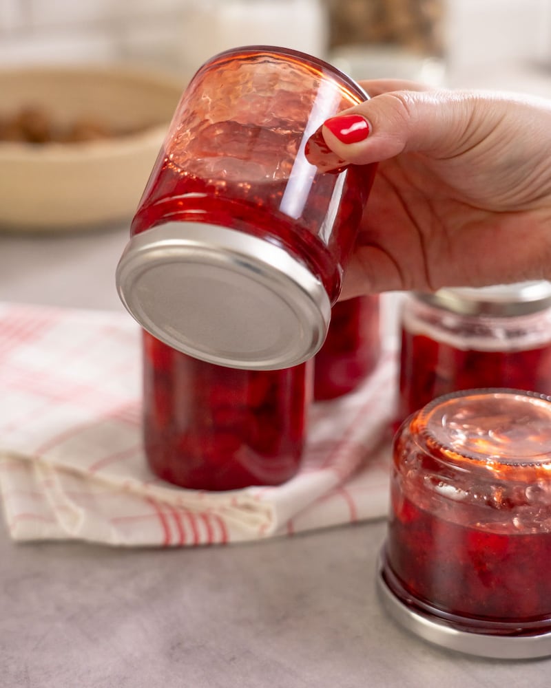 Dieses Bild zeigt wie die Erdbeermarmelade im Glas umgedreht wird.