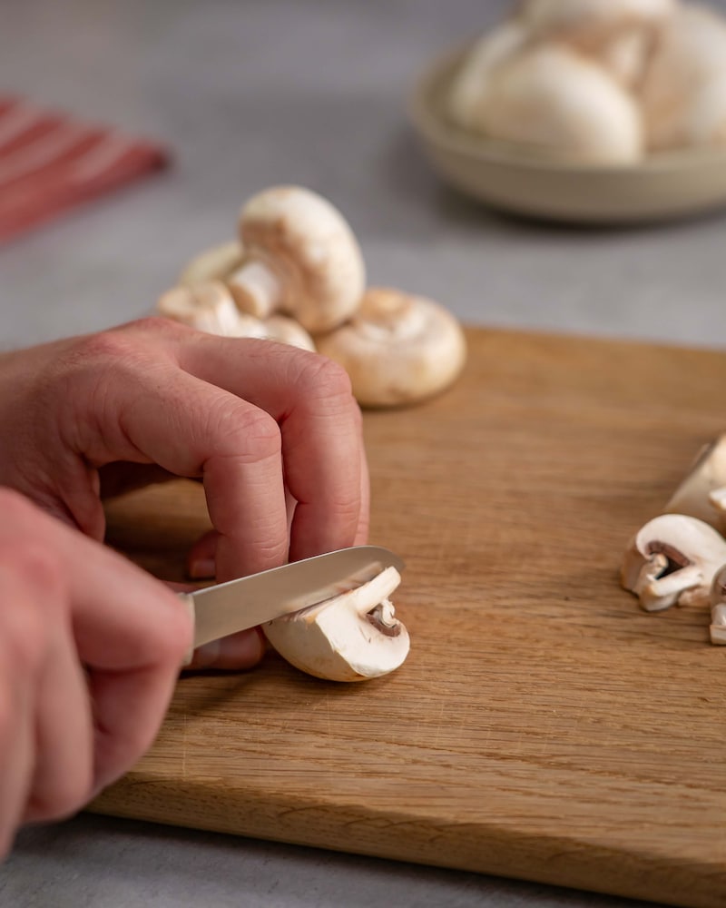Dieses Bild zeigt, wie die Champignons geschnitten werden.