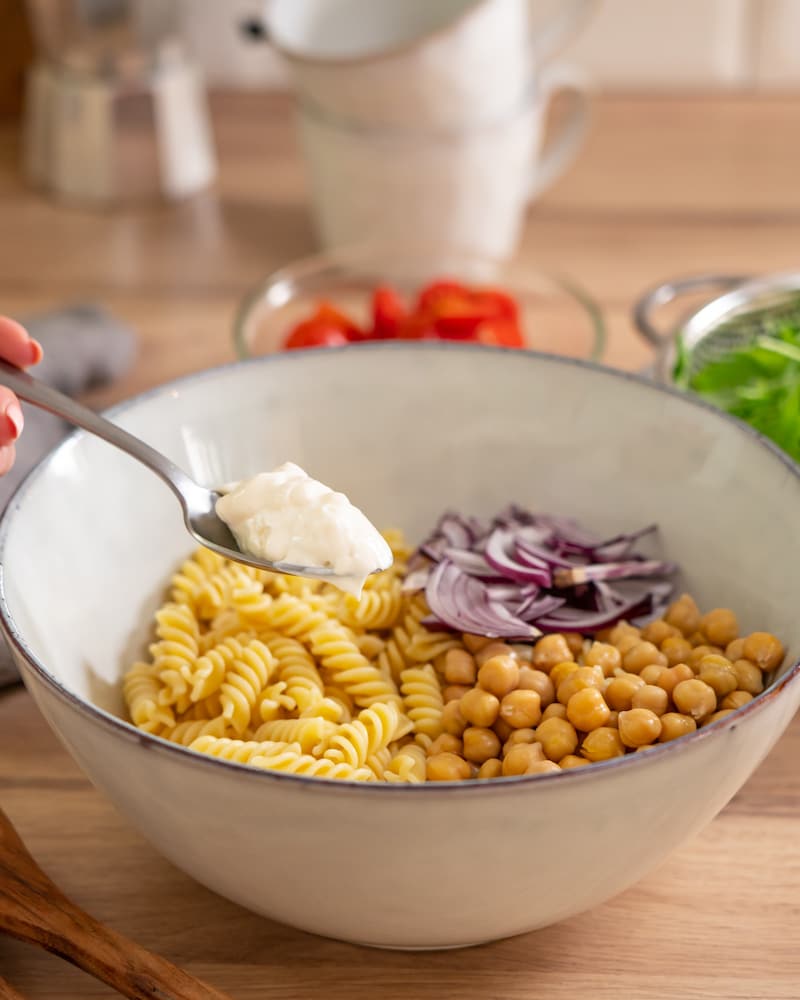 Das Bild zeigt, wie der Salat gemischt wird.