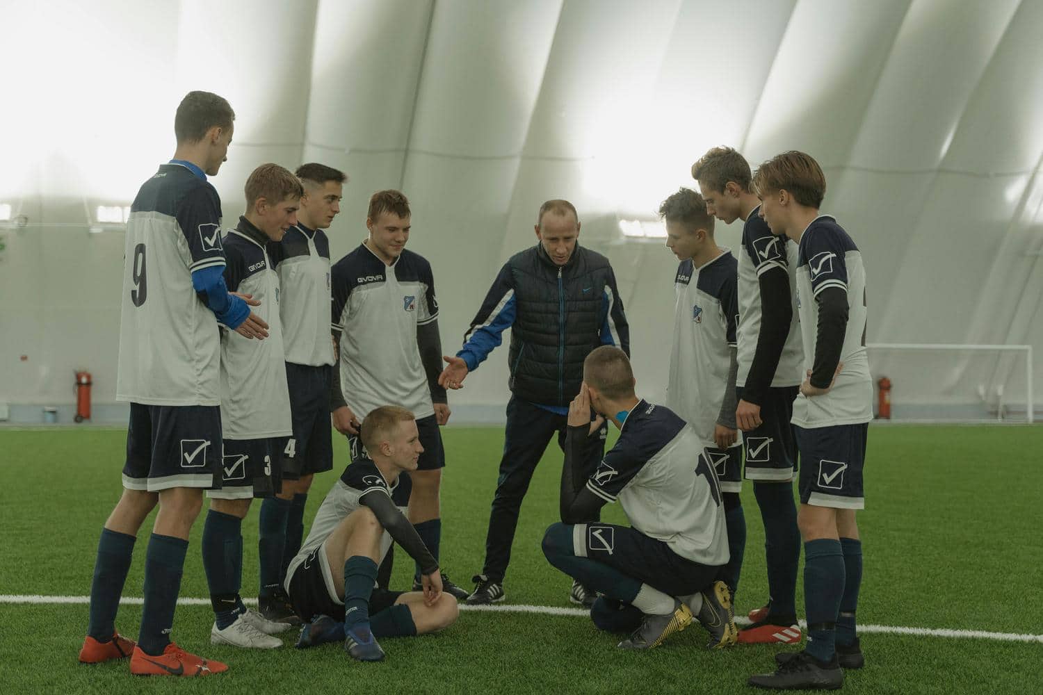 Die Fußballmannschaft bespricht ihren Spielplan mit dem Trainer