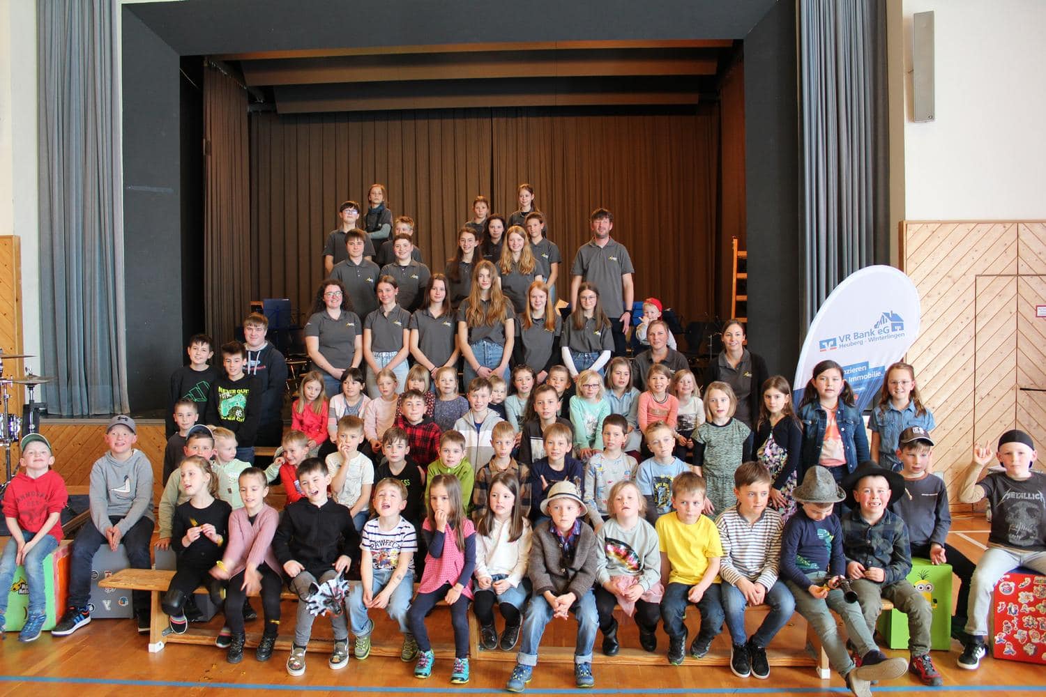 Kinder und Vereinsmitglieder laecheln in die Kamera