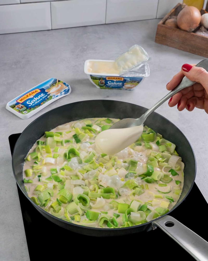 Dieses Bild zeigt, wie Schmelzkäse hinzugegeben wird.