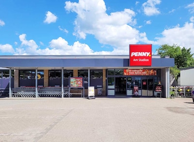Sie sehen den Eingang vom Penny Markt in Flensburg Tilsiter Str. 2-4