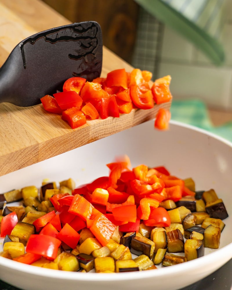 Dieses Bild zeigt wie die Paprika in die Pfanne gegeben wird.