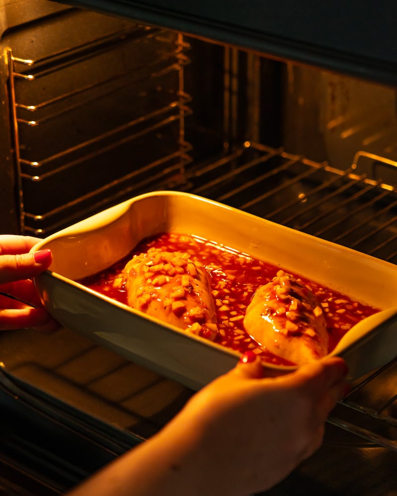 Dieses Bild zeigt wie das Fleisch mit der Marinade in den Ofen gegeben wird.