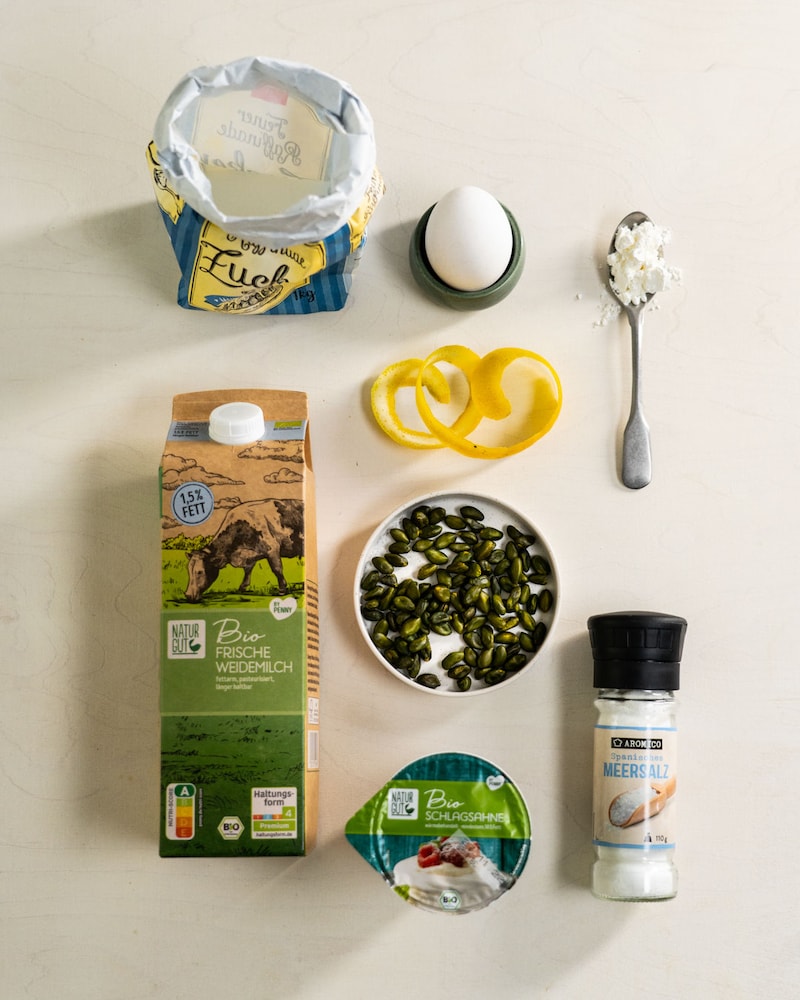 Dieses Bild zeigt die benötigen Zutaten für das Rezept. Diese sind Milch, Sahne, Pistazienkerne, Salz, Zitronenschale, Zucker, Ei, Speisestärke. 