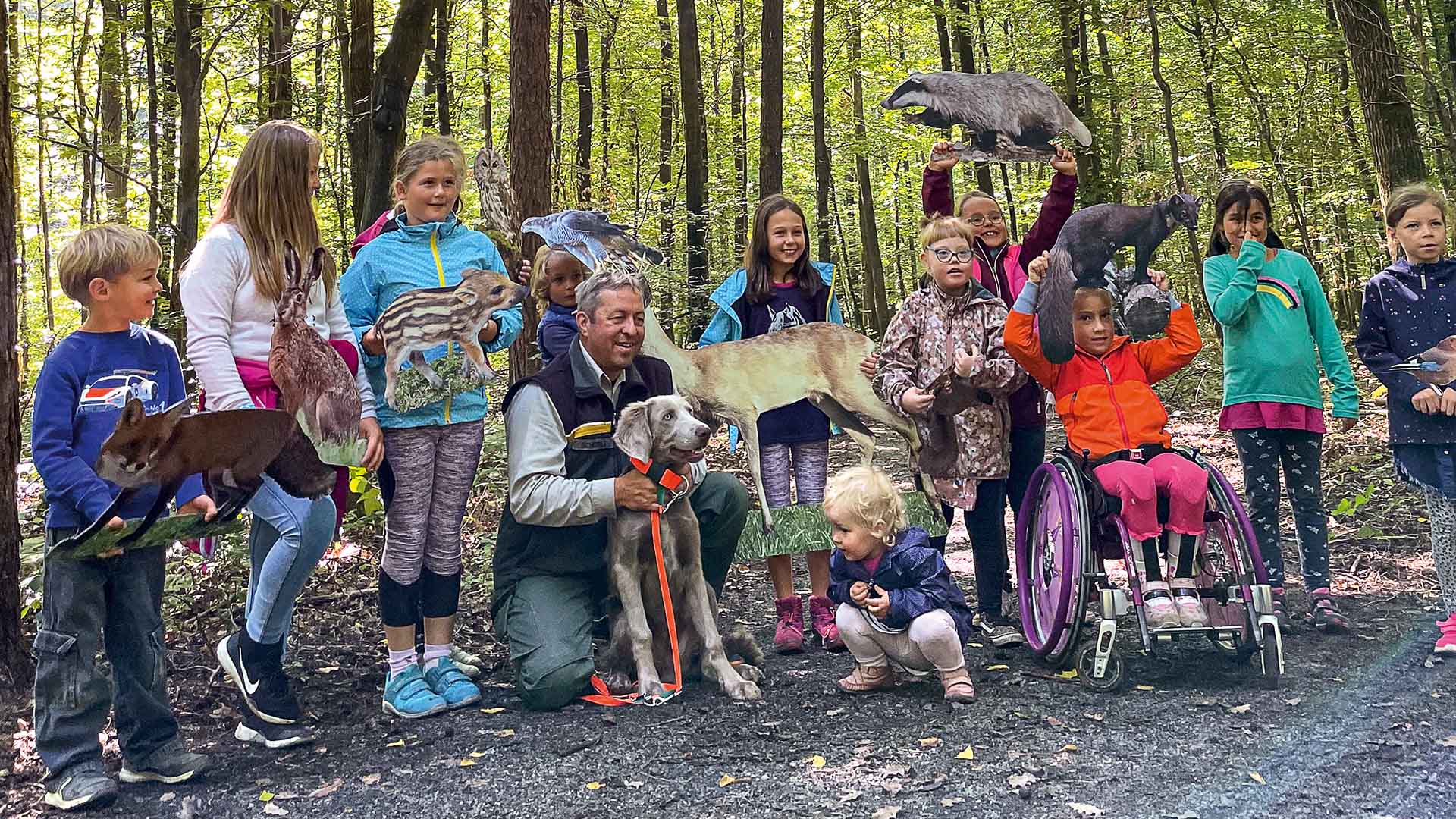 Eine Gruppe Kinder mit Waldtieren im Wald