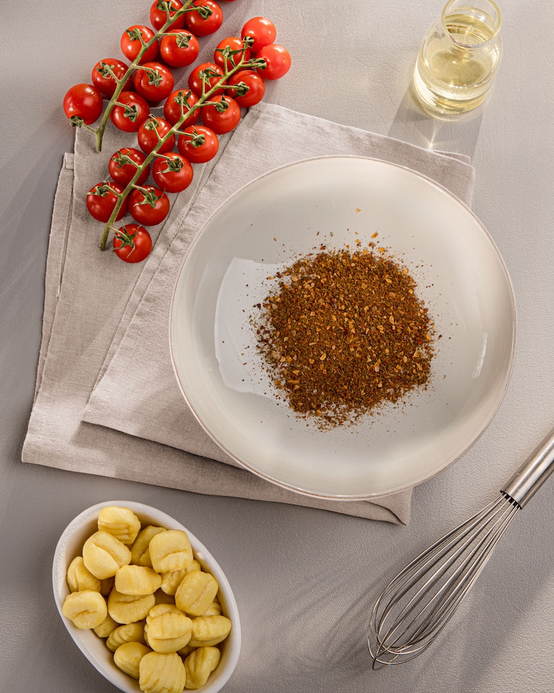 Dieses Bild zeigt die Gewürze, Tomaten und Gnocchi in einer Schüssel.