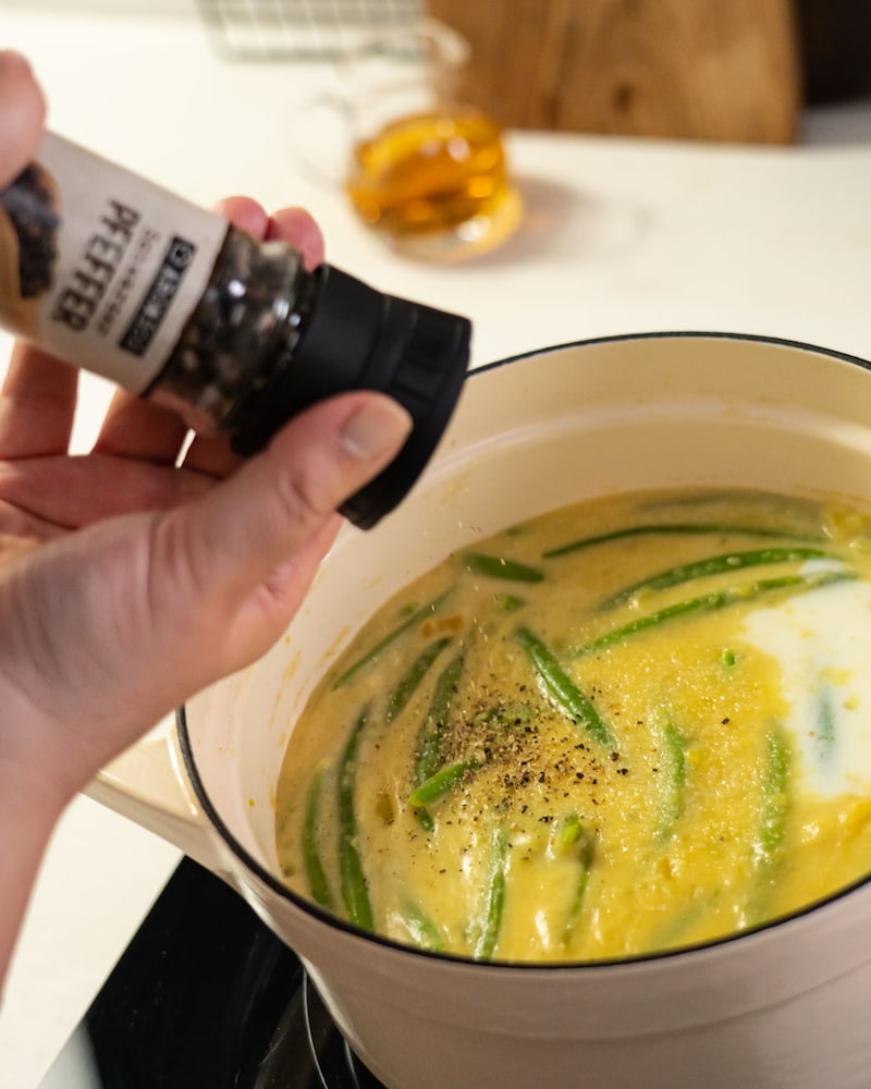 Dieses Bild zeigt wie die Suppe gepfeffert wird.