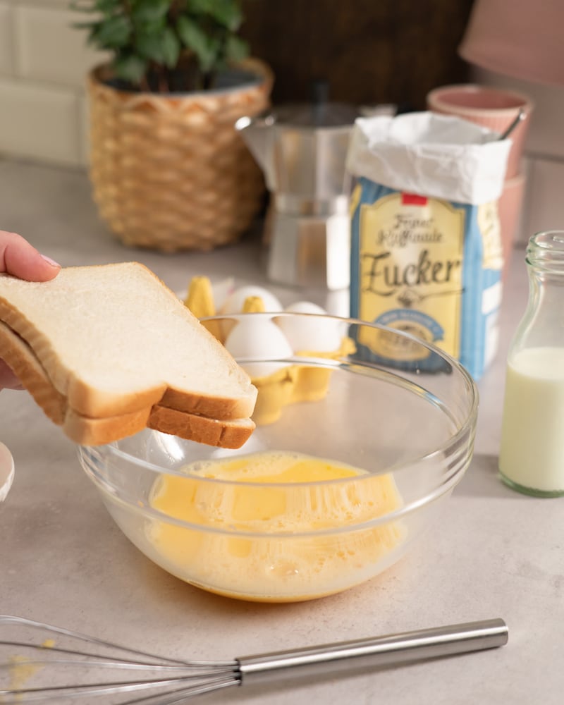 Dieses Bild zeigt wie der Toast in die Ei-Masse gegeben wird.