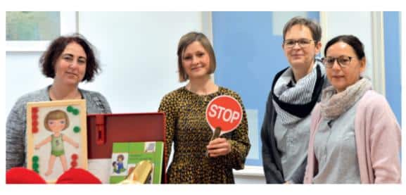 Vereinsmitglieder mit Projektmaterial laecheln in die Kamera