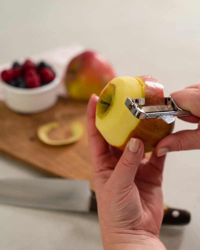 Auf diesem Bild siehst du wie ein Apfel geschält wird.