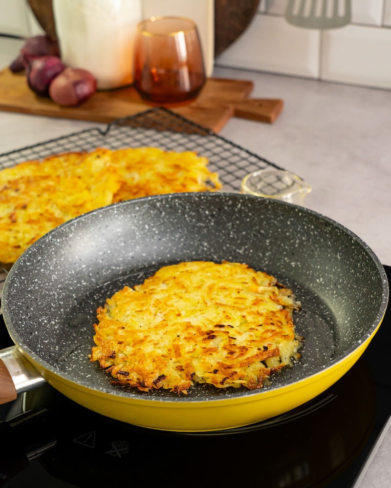 Dieses Bild zeigt wie die Kartoffelrösti in der Pfanne angebraten werden.