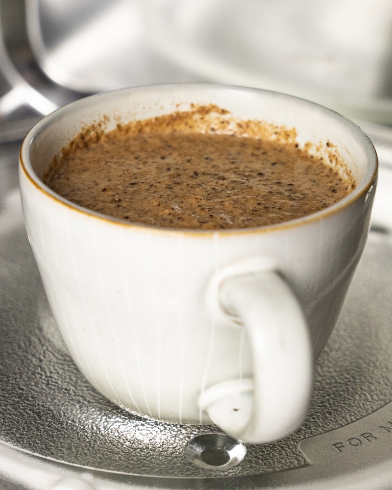 Auf diesem Bild siehst du wie der Teig in der Tasse eine eine Mikrowelle gegeben wird.