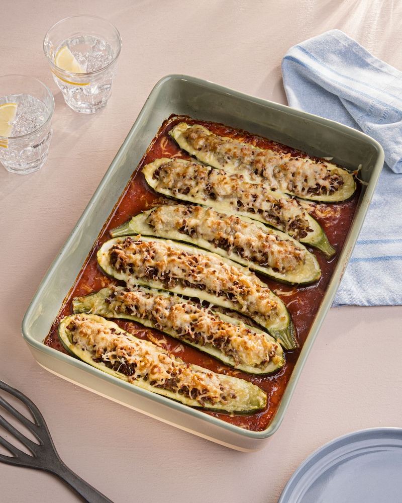 Das Bild zeigt eine Auflaufform in der Zucchini-Hälften mit Hackfleischfüllung gebacken wurden.