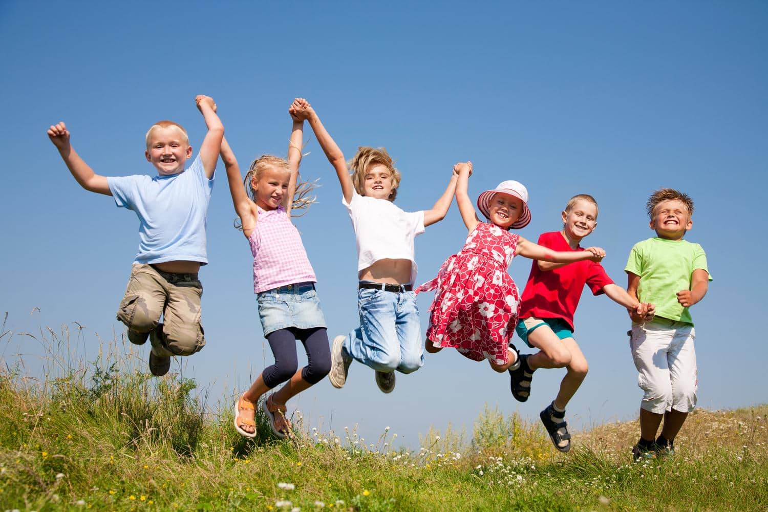 Kinder springen gluecklich in die Luft