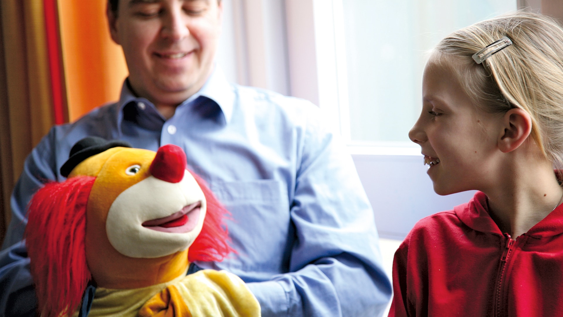 Mädchen wird von einem Clown aufgeheitert