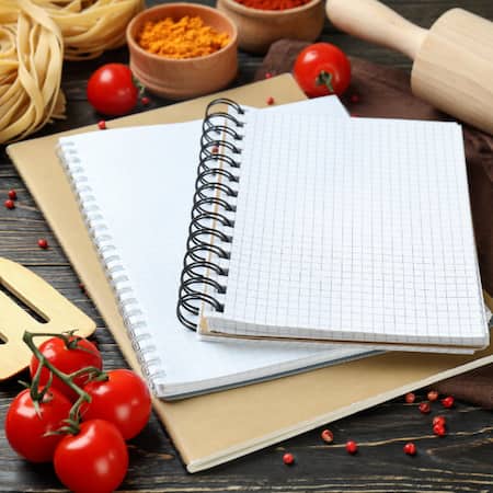 Block mit Ringbuch auf einem Holztsich.