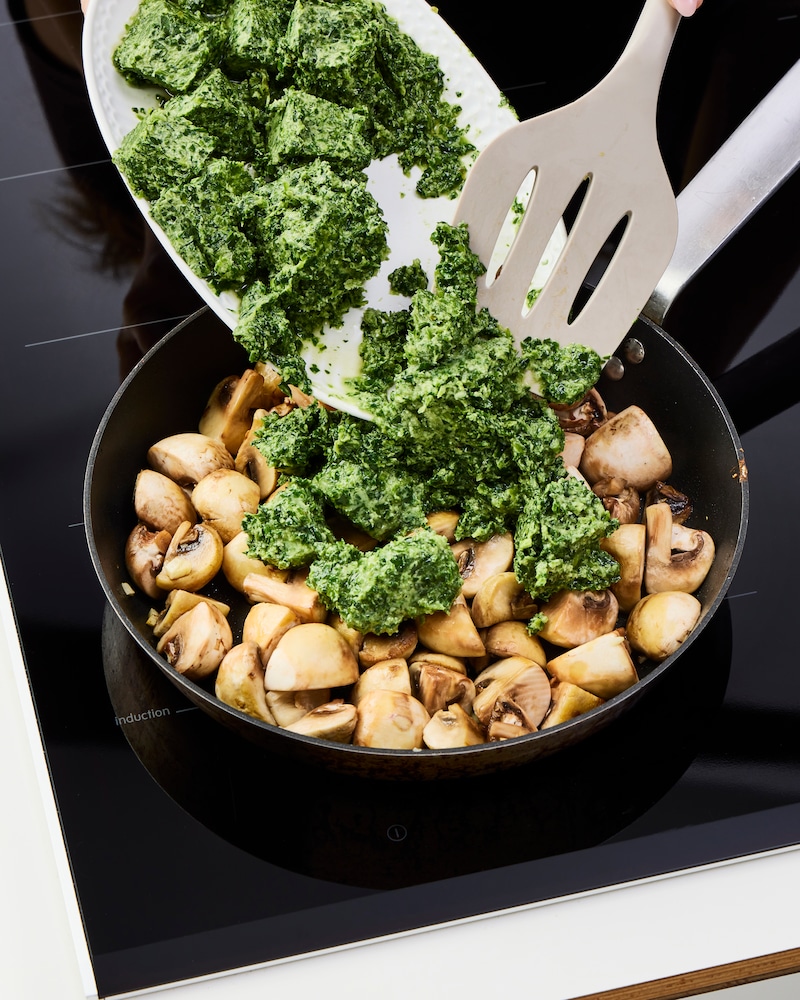 Dieses Bild zeigt, wie Spinat dazugegeben wird.