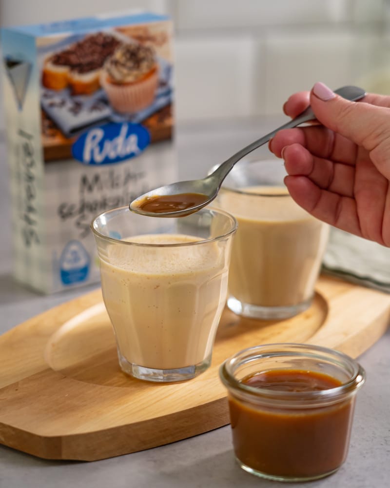 Dieses Bild zeigt wie Schoko-Kaffee über die Panna-Cotta gegeben wird.