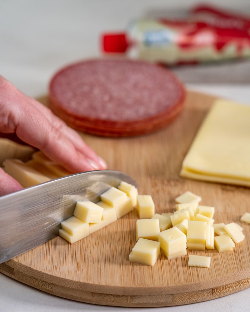 Auf diesem Bild siehst du wie Käse geschnitten wird.