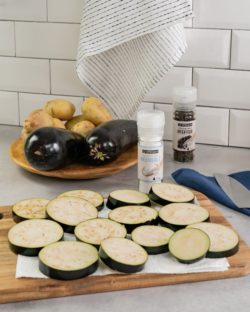 Auf diesem Bild siehst du wie eine Aubergine gesalzen wird.