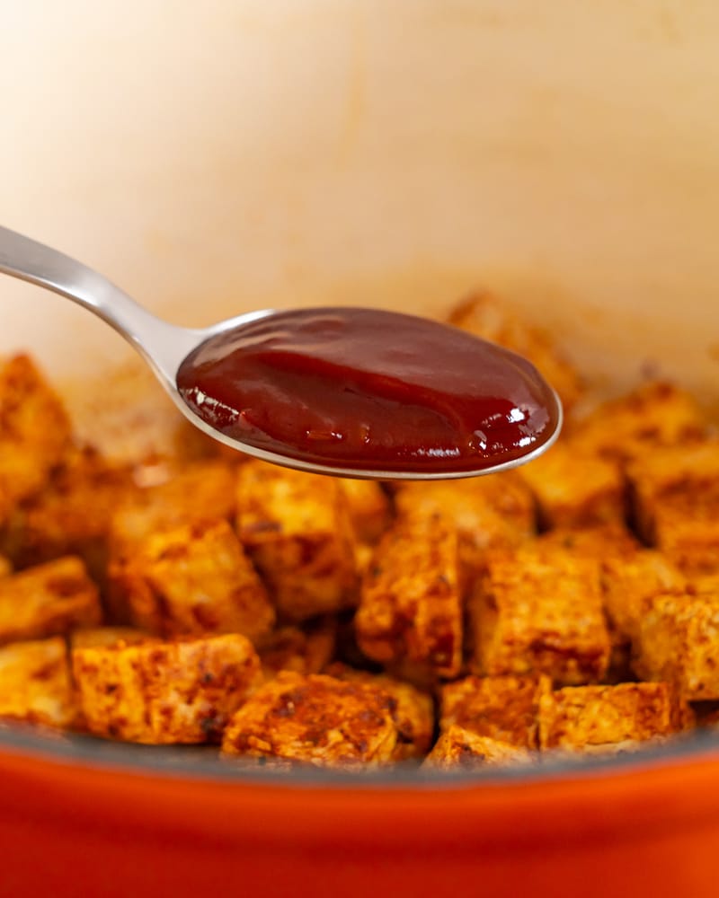 Dieses Bild zeigt wie ein Löffel Sauce hinzugegeben wird.