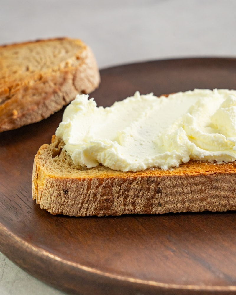 Dieses Bild zeigt mit Frischkäse bestrichenes Brot.