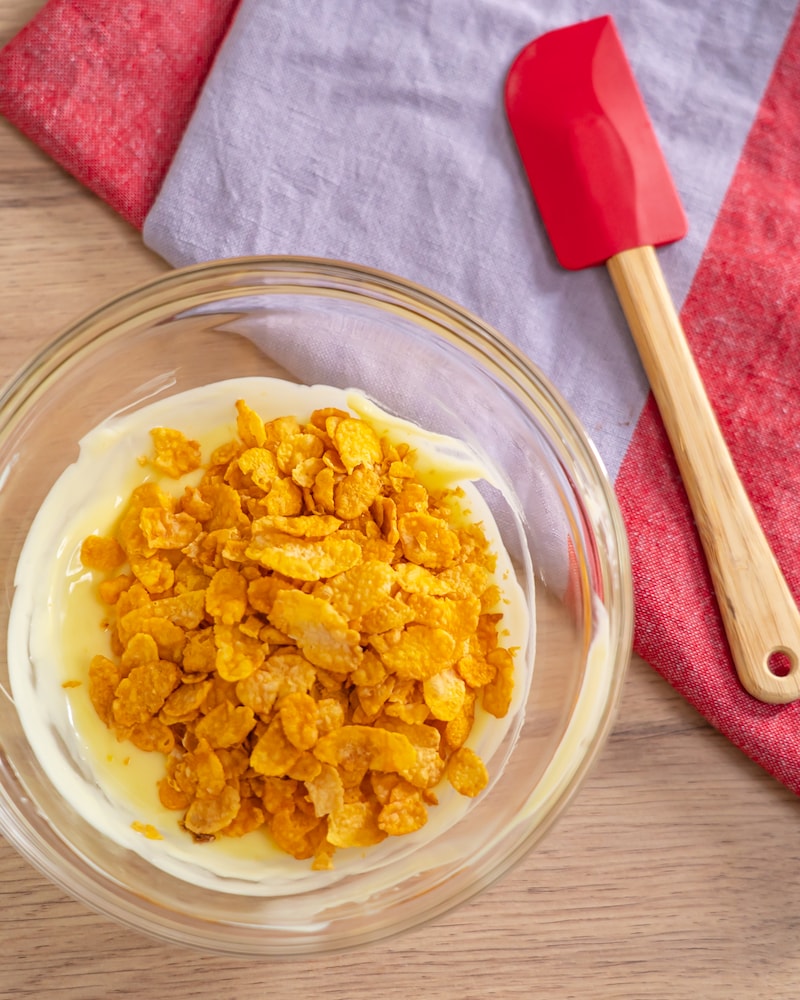 Dieses Bild zeigt das hinzufügen der Cornflakes in die weißen Schokolade.