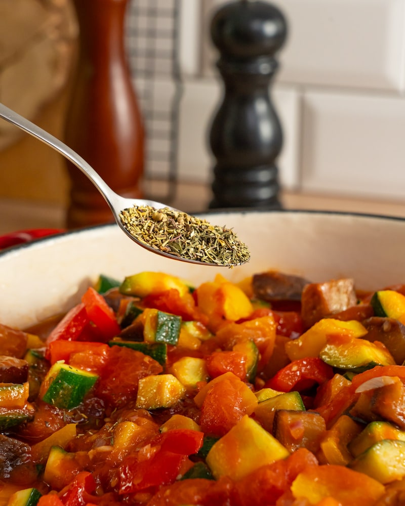 Dieses Bild zeigt wie das Ratatouille gewürzt wird.