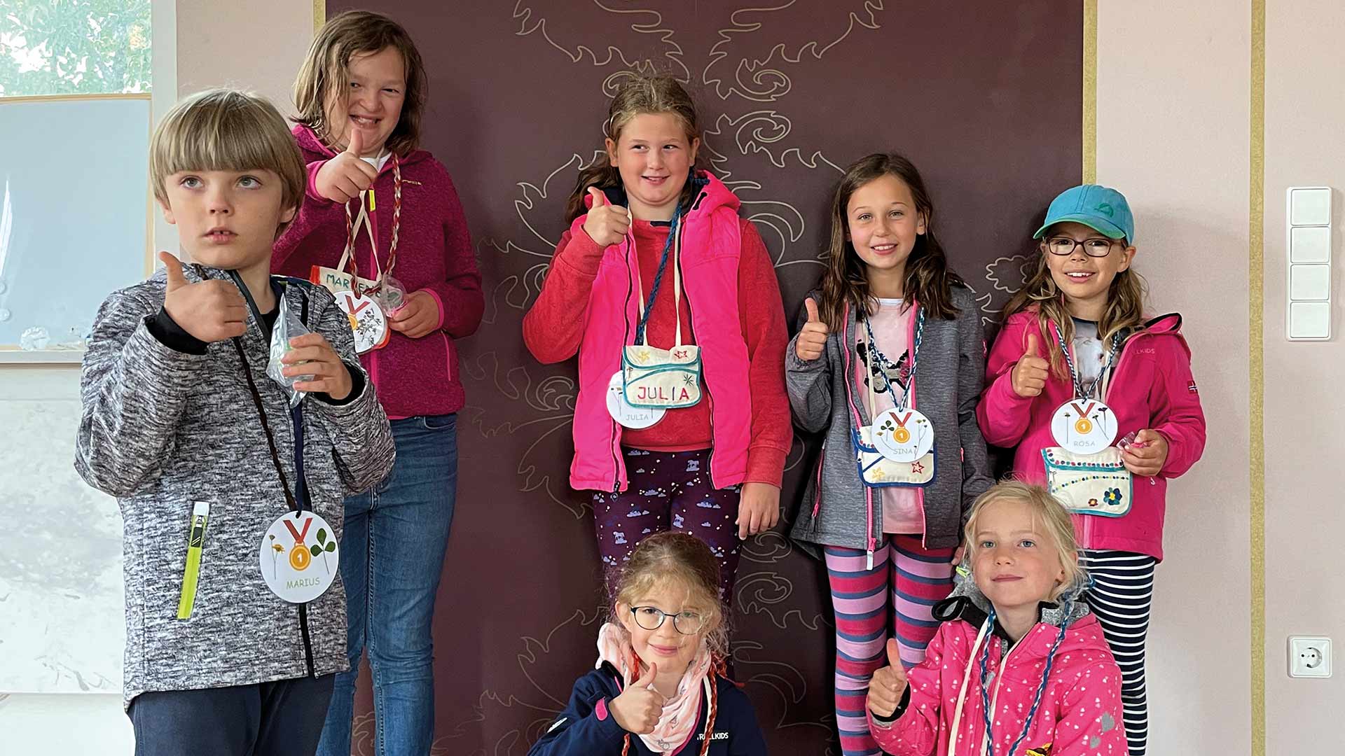 Kindergruppe zeigt Daumen
