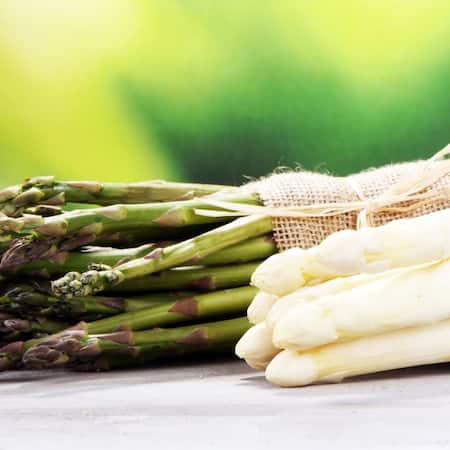 Grüner und weißer Spargel auf einem Holztisch