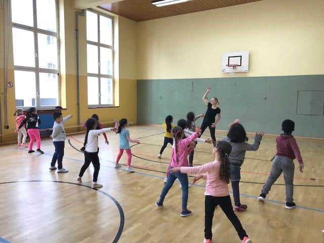 Kinder beim Tanzen in der Sporthalle