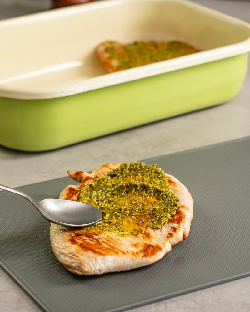 Dieses Bild zeigt wie das Putenschnitzel mit Pesto mariniert wird.