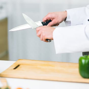 Ein Messer wird mit einem anderen Messer geschliffen.