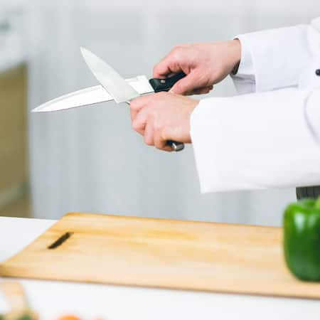 Ein Messer wird mit einem anderen Messer geschliffen.