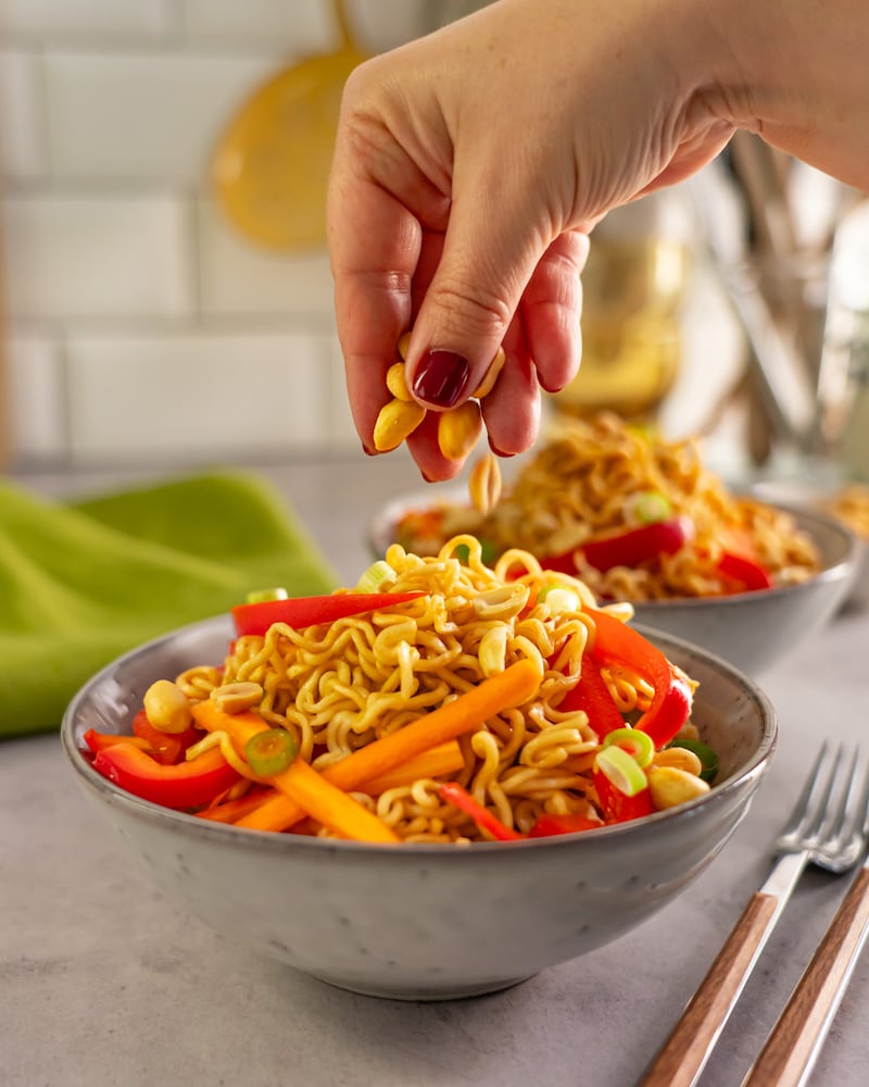 Dieses Bild zeigt wie die Erdnüsse auf den Salat gegeben werden.
