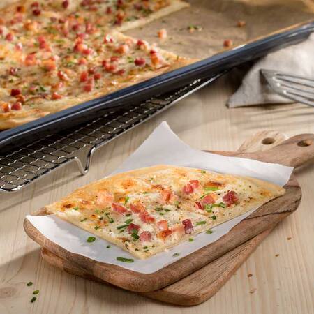 Das Bild zeigt einen knusprigen Flammuchen mit Speck. 