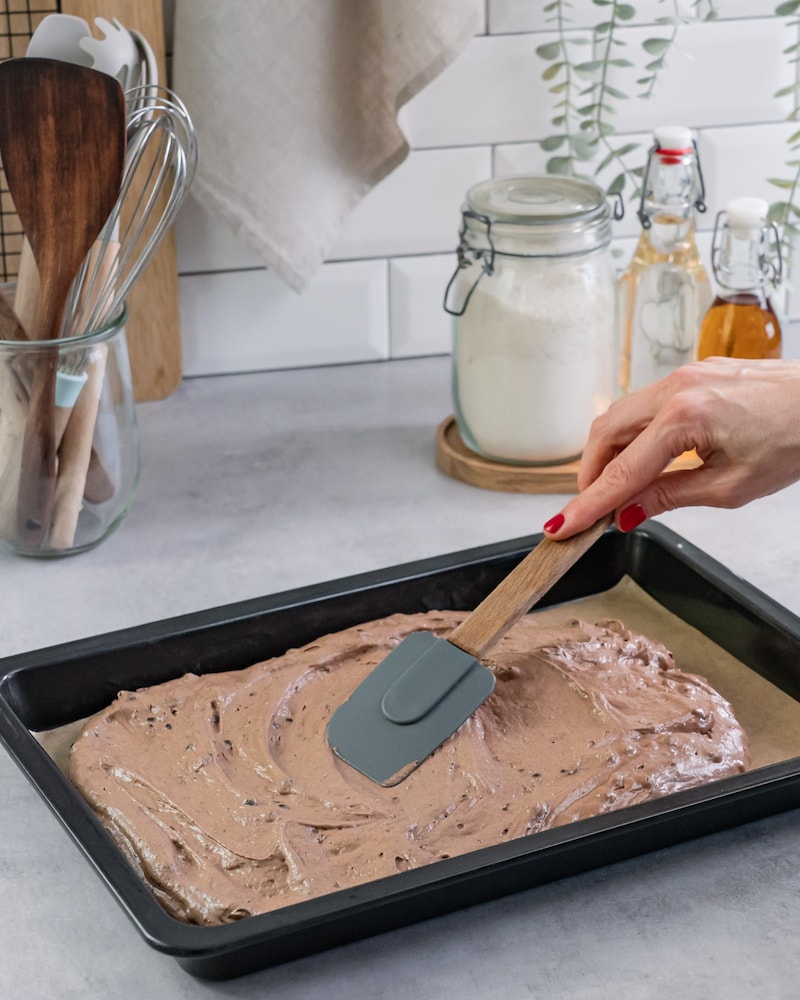 Diese Bild zeigt wie der fertige Teig auf das Backblech verteilt wird.