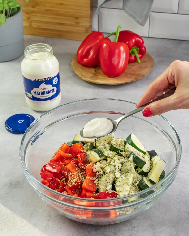 Dieses Bild zeigt wie Salatmayonnaise hinzugegeben wird.