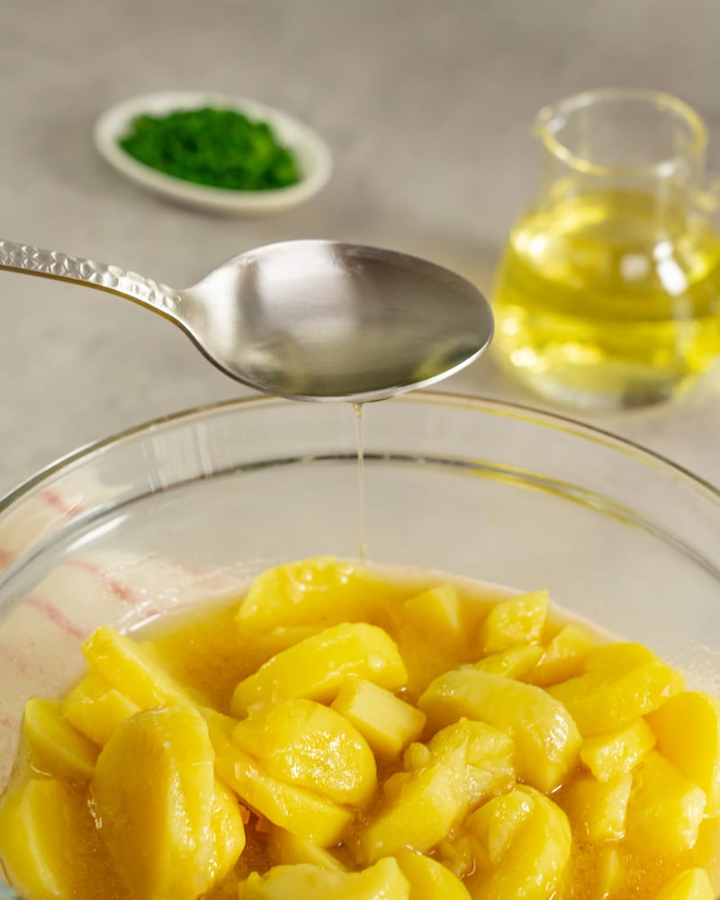 Dieses Bild zeigt wie das Dressing auf die Kartoffeln gegeben wird.